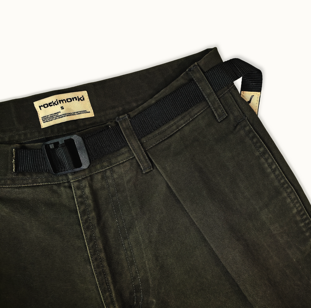 Dark green pants with a black belt and visible brand label on a white background